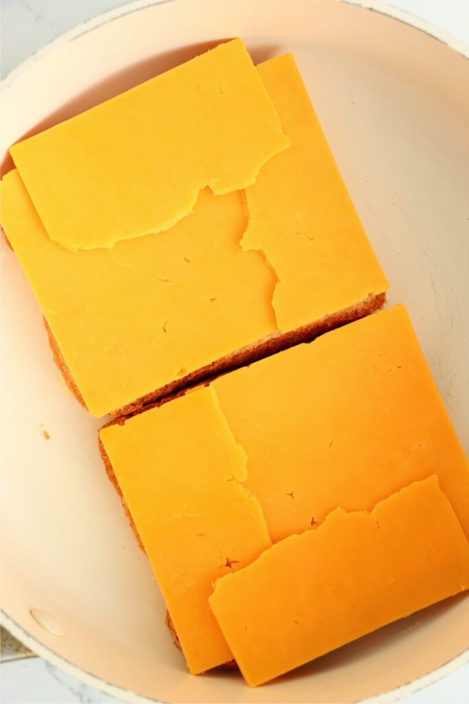 Overhead shot of bread topped with cheese in pan