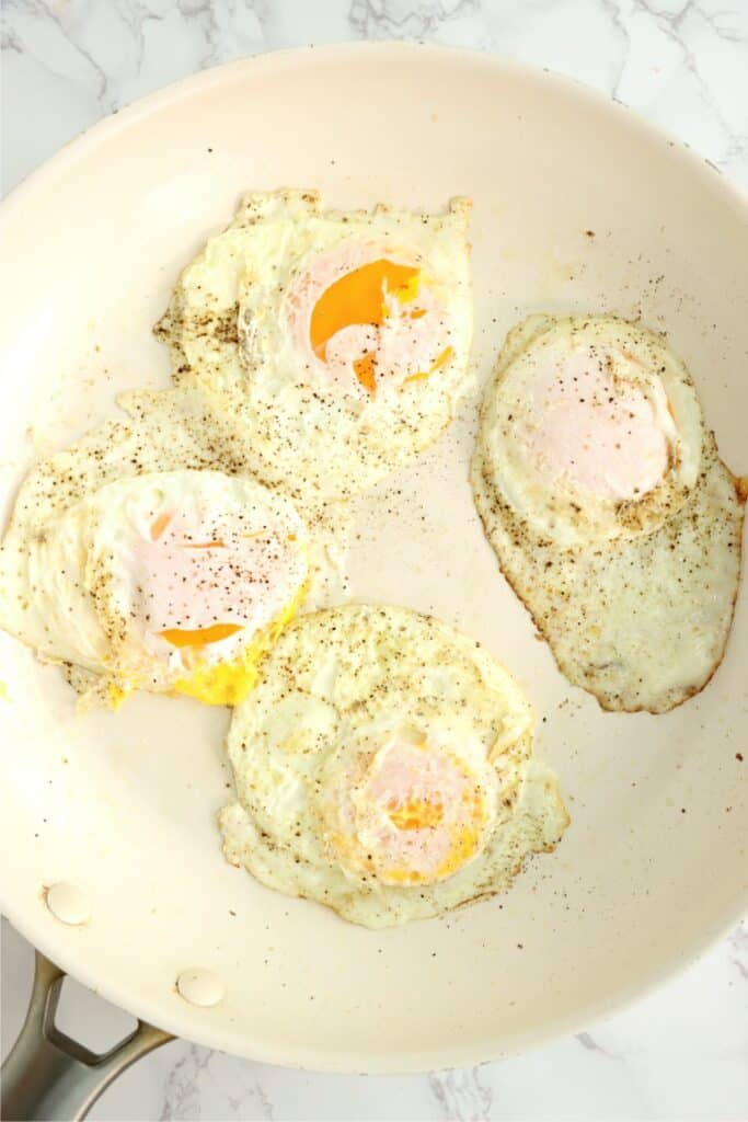 Overhead shot of fried, sunny side up eggs in pan