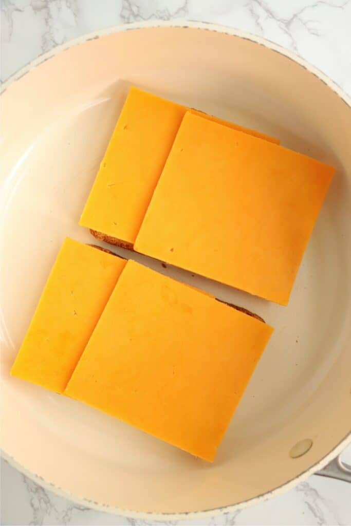 Overhead shot of bread topped with cheese in skillet