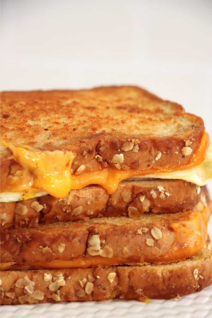 Closeup shot of grilled cheese and egg sandwiches stacked atop one another