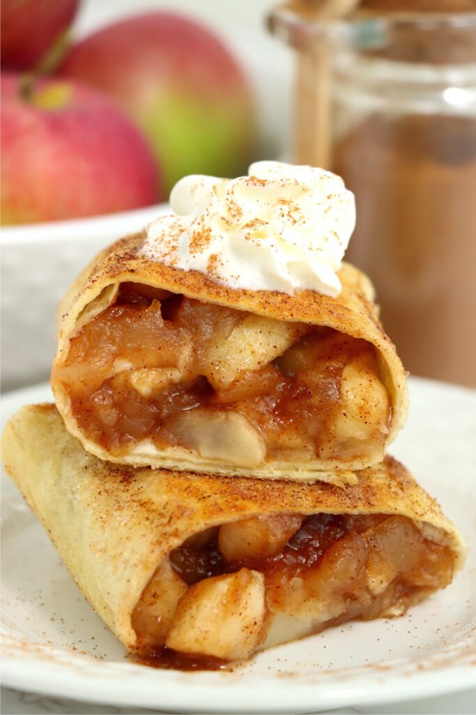 Closeup shot of two homemade apple wraps with whipped cream on plate