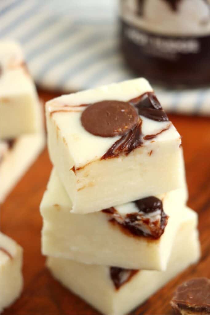 Closeup shot of three squres of moosetracks fudge stacked atop one another. 