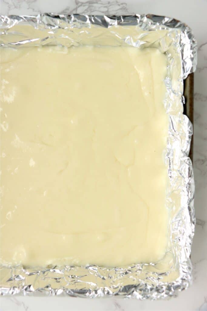 Overhead shot of white fudge in baking dish lined with foil