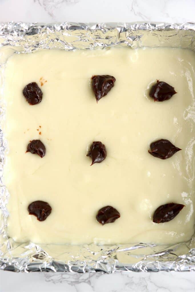 Overhead shot of white fudge topped with dollops of hot fudge sauce.