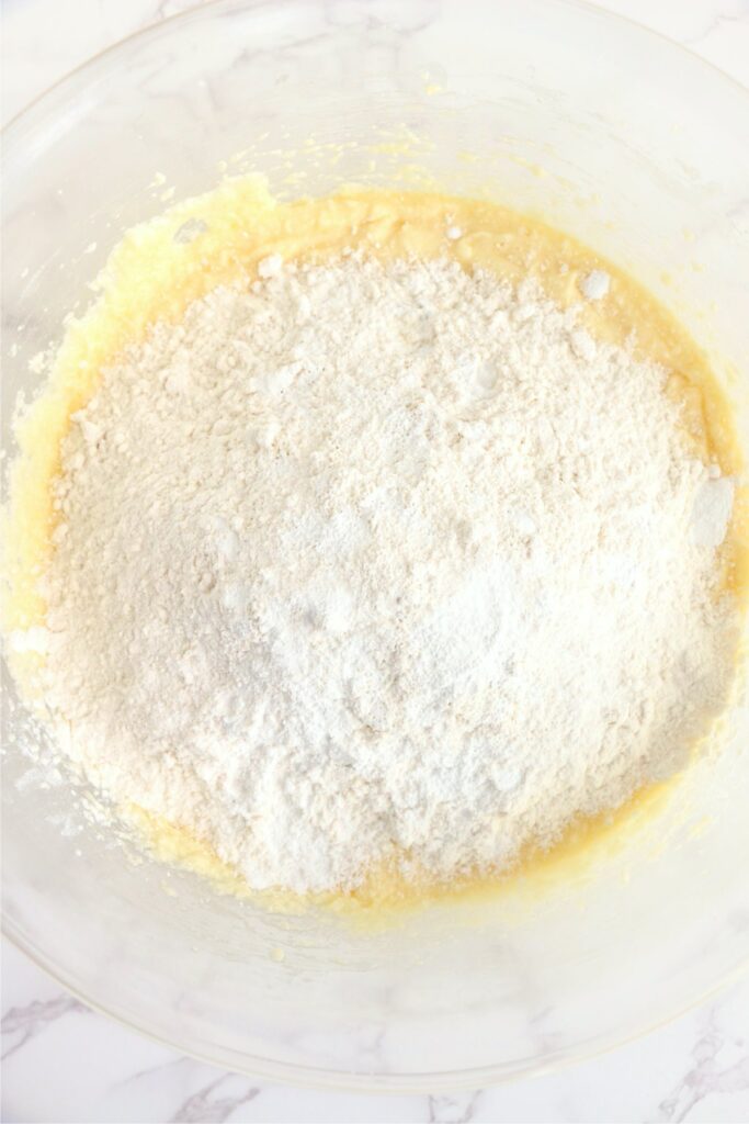 Overhead shot of flour mixture in bowl with wet cake ingredients