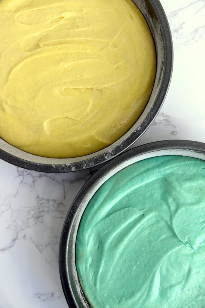 Overhead shot of pastel cake batter in cake pans.