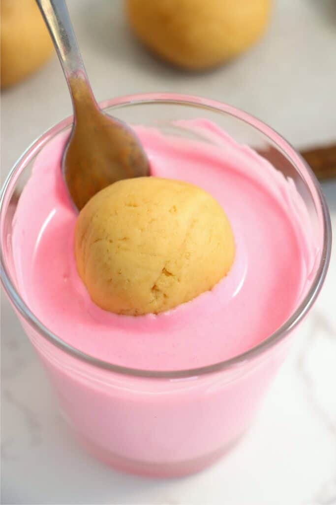 Closeup shot of Oreo ball being dipped into pink almond bark