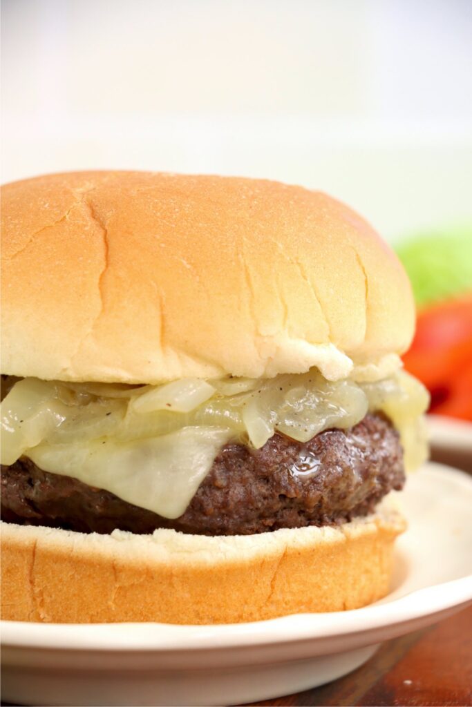 Closeup shot of grilled onion cheddar burger on plate