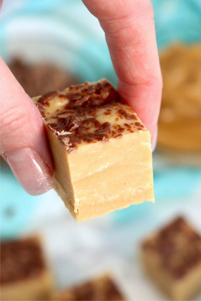 Closeup shot of hand holding a piece of no bake peanut butter fudge