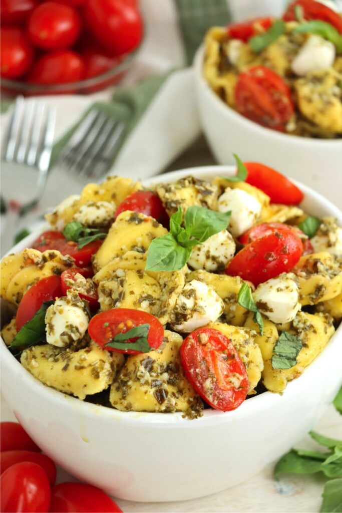 Closeup shot of bowlfuls of pest tortellini salad