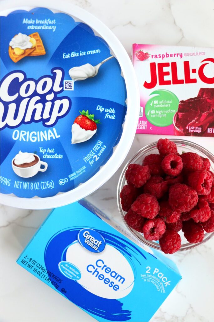 Overhead shot of individual raspberry Cool Whip dessert ingredients on table