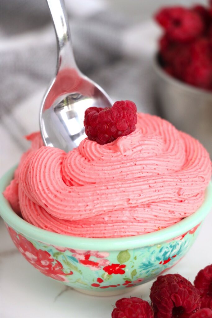 Closeup shot of bowlful of raspberry Cool Whip dessert with spoon