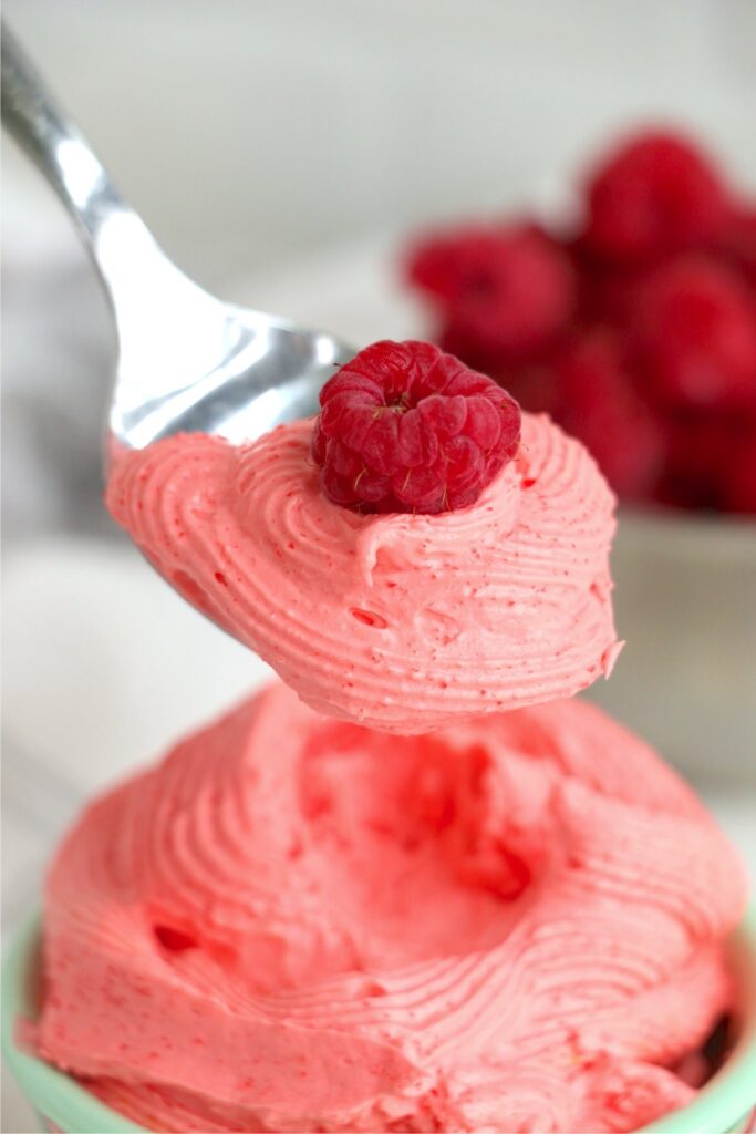 Closeup shot of spoonful of raspberry Cool Whip dessert over bowl of morre dessert