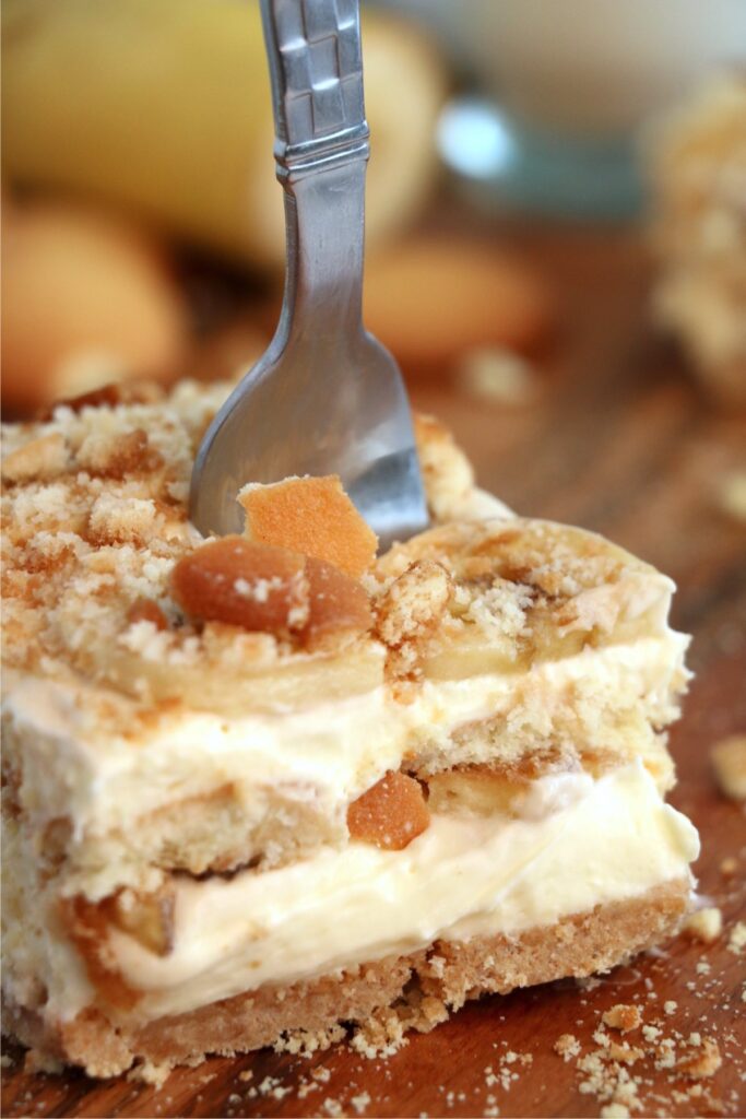 Closeup shot of fork stuck into a slice of banana pudding lasagna. 