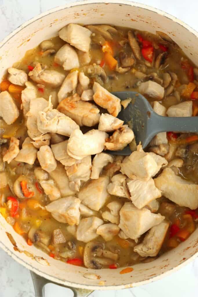 Overhead shot of chicken and vegetables in sauce in pan