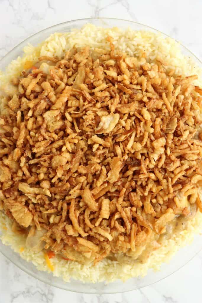Overhead shot of chicken rice crust pie topped with French fried onions.