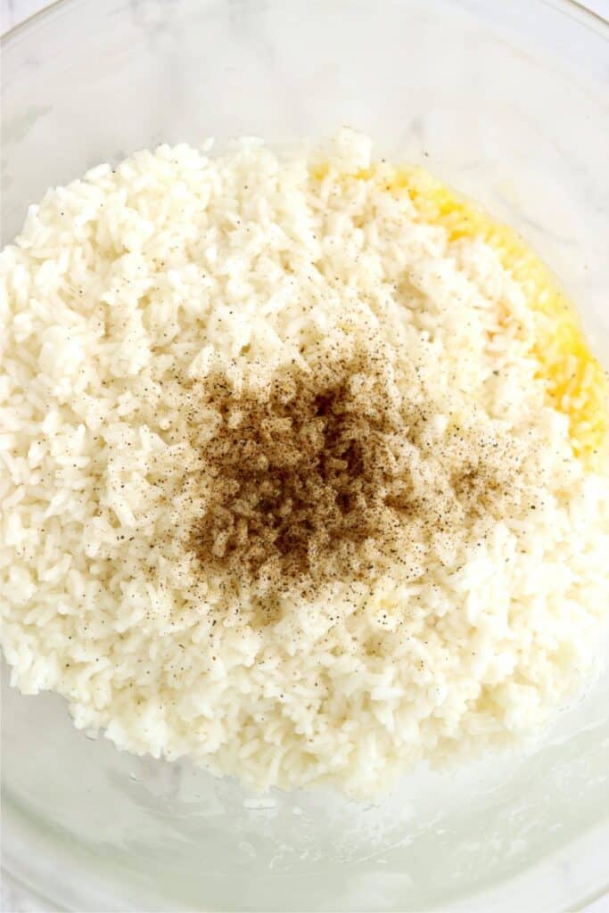 Closeup overhead shot of rice, egg, and pepper in mixing bowl