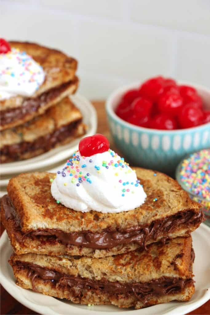 Closeup shot of stack of chocolate French toast on plate with more French toast on a plate in the background