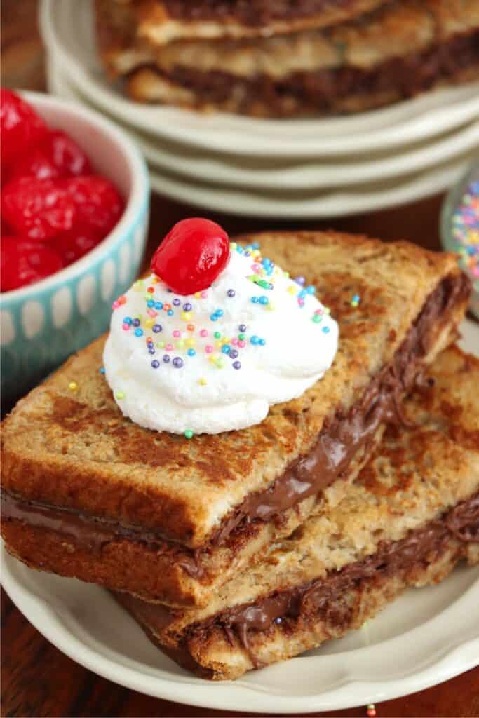 Closeup shot of stack of chocolate French toast topped with whipped cream on plate