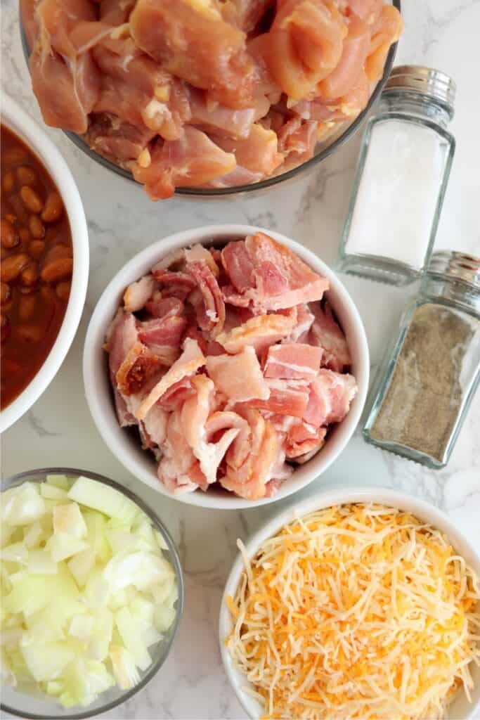 Closeup overhead shot of individual beans bacon and chicken in bowls on table