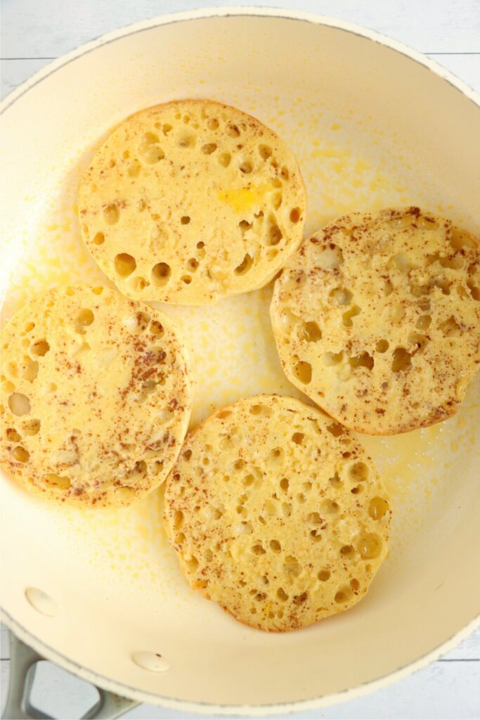 Overhead shot of uncooked English muffin French toast in skillet.