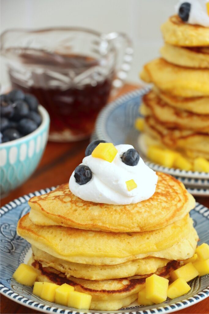 Closeup shot of mango pancakes stacked atop one another on plate