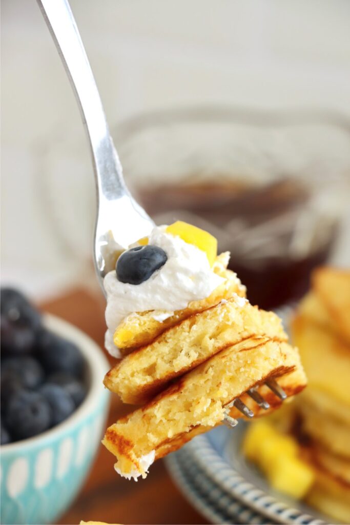 Closeup shot of forkful of mango pancakes.