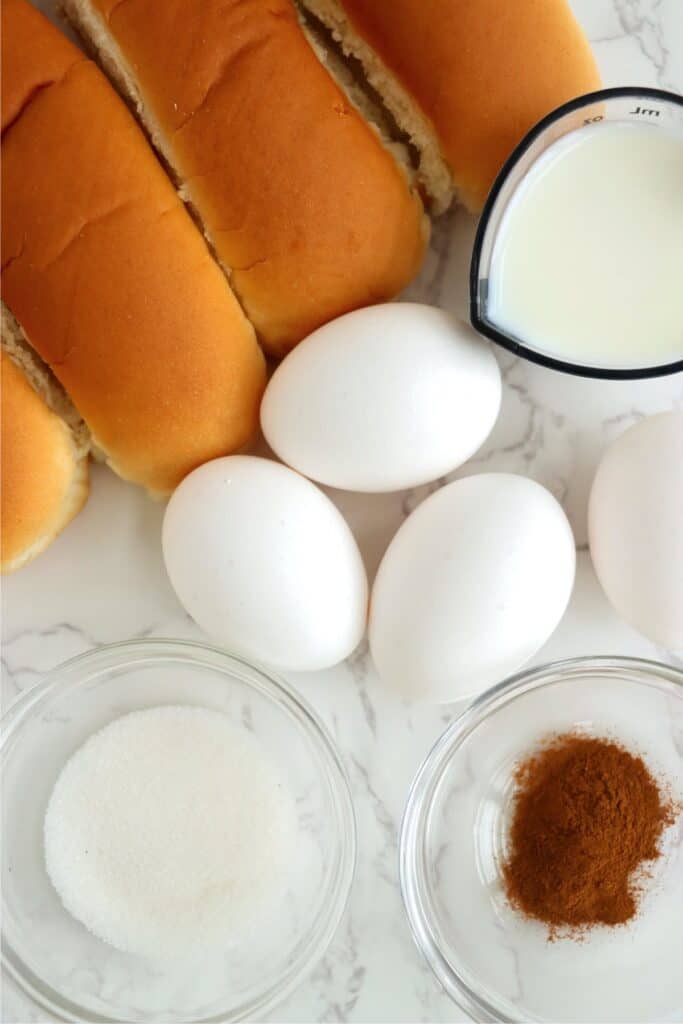 Overhead shot of individual hot dog bun French toast ingredients on table