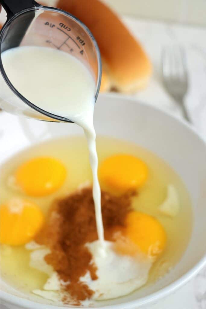 Milk being poured into bowl of egg mixture