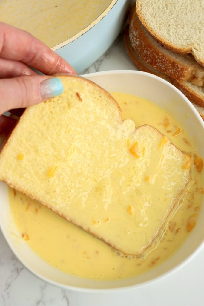 Overhead shot of bread being soaked in egg mixture