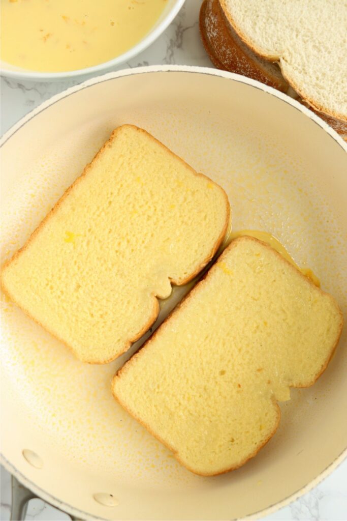 Overhead shot of uncooked mango French toast in skillet