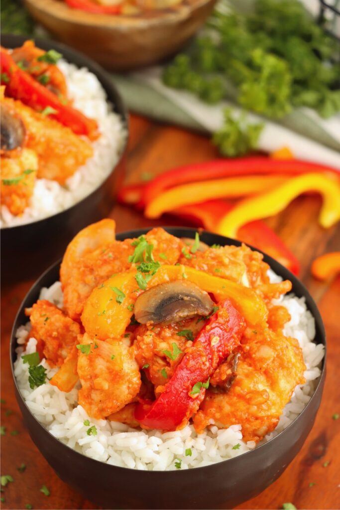 Overhead shot of red chicken over rice in bowl