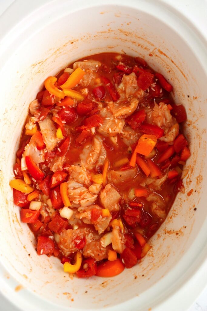 All taco chicken and rice ingredients stirred together in slow cooker