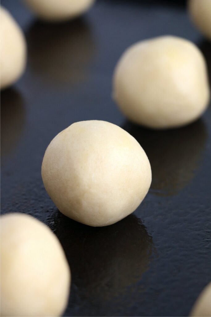 Closeup shot of sugar cookie dough balls on baking sheet