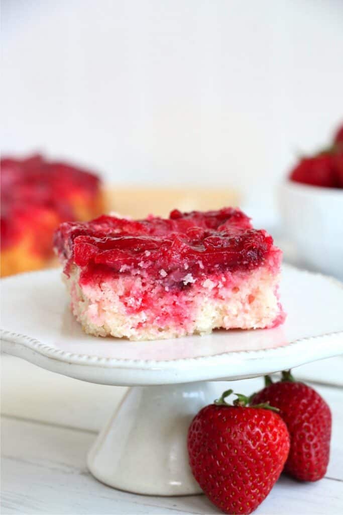 Closeup shot of easy strawberry dump cake on cake stand. 