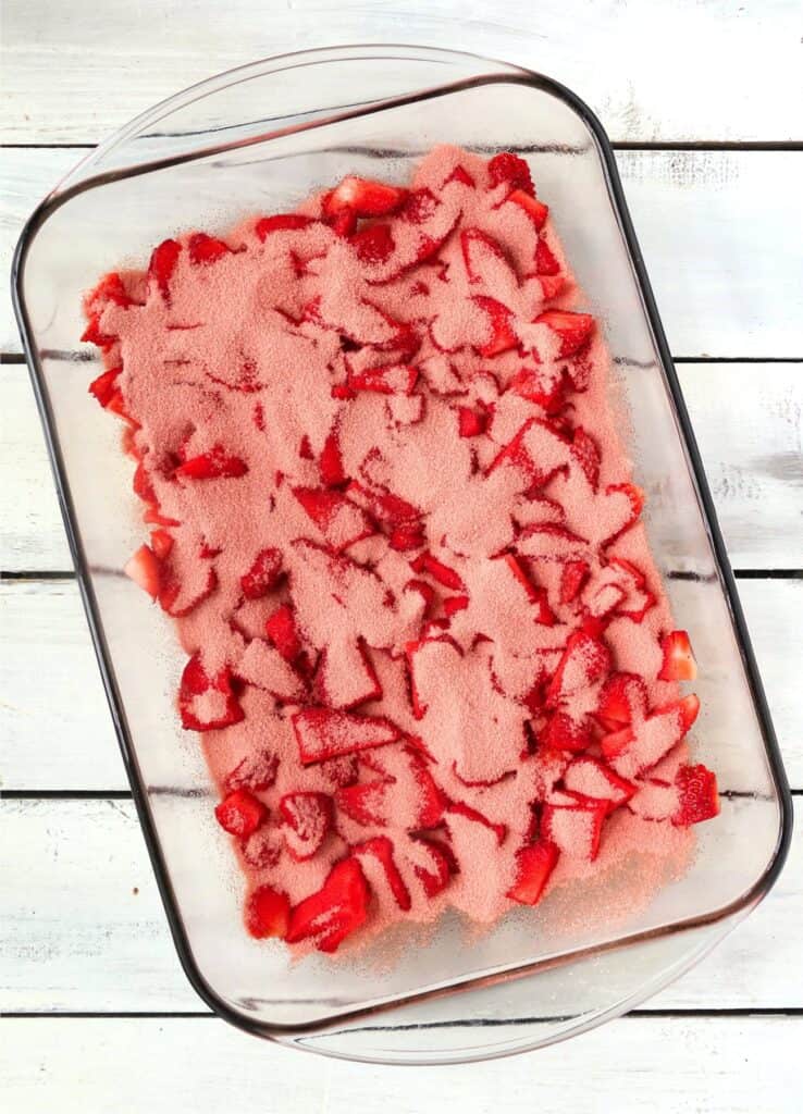 Overhead shot of strawberries covered in Jello in baking dish