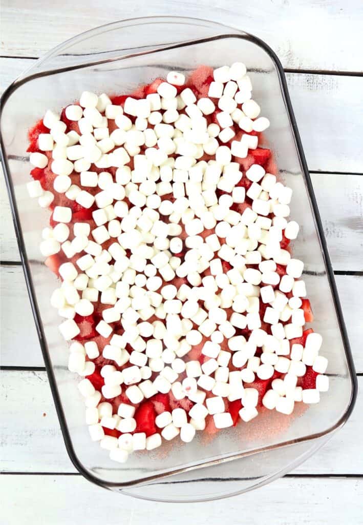 Overhead shot of strawberries, Jello, and mini marshmallows in baking dish. 