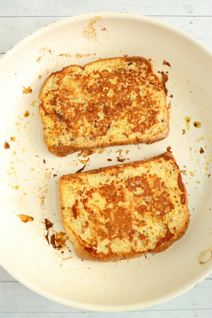 Overhead shot of golden brown sweet Hawaiian bread French toast in skillet