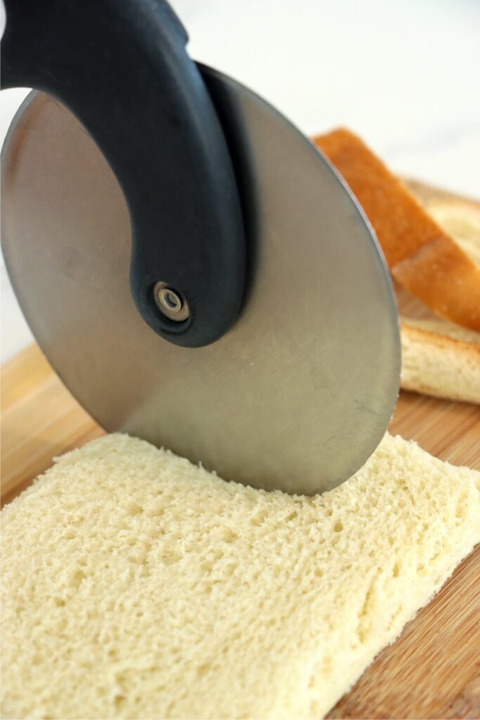 Closeup shot of bread being cut into strips with pizza cutter