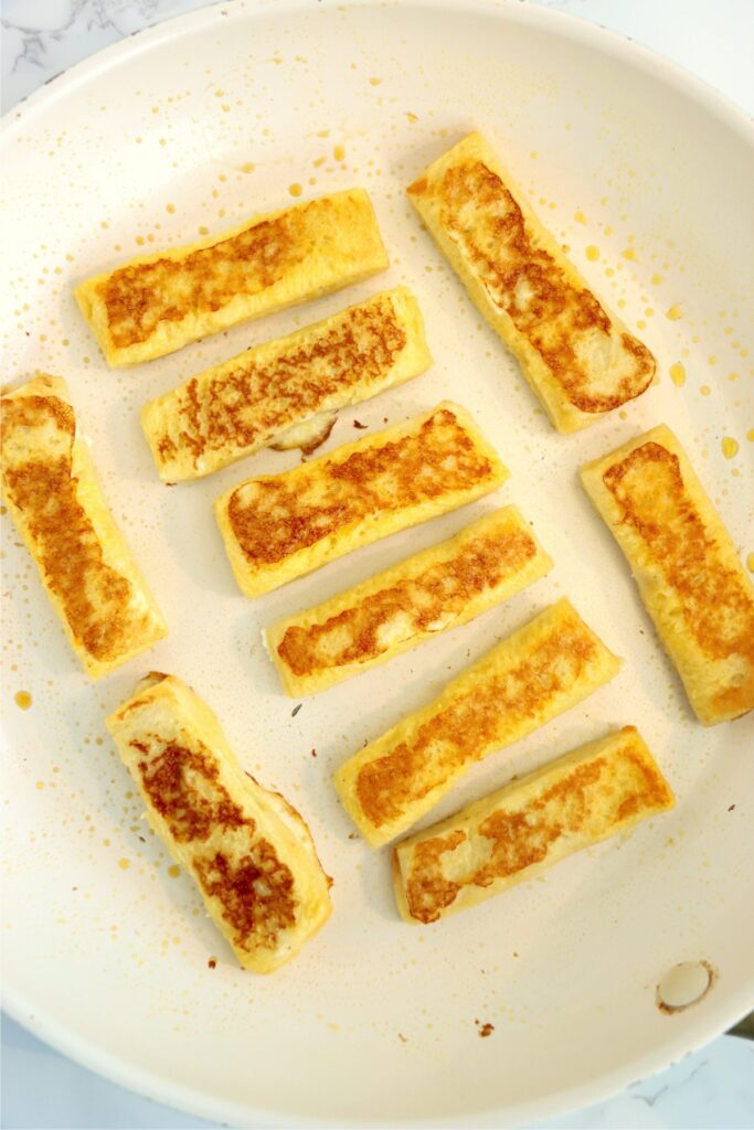 Overhead shot of golden brown Jack in the Box French toast sticks in skillet