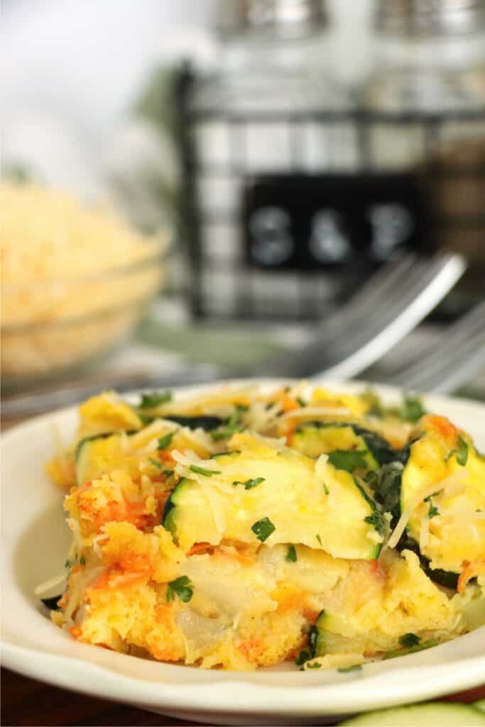 Closeup shot of slice of zucchini carrot casserole on plate.