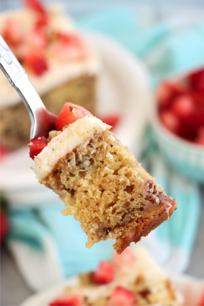 Closeup shot of forkful of strawberry banana cake. 