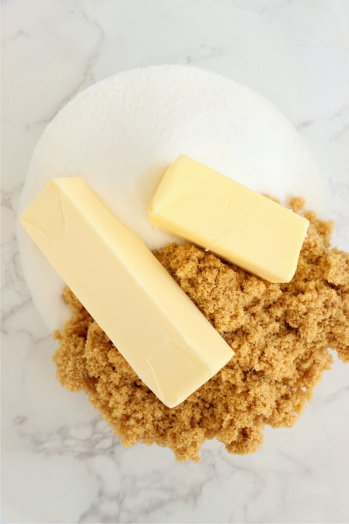 Closeup overhead shot of butter sticks  and brown and white sugars in bowl