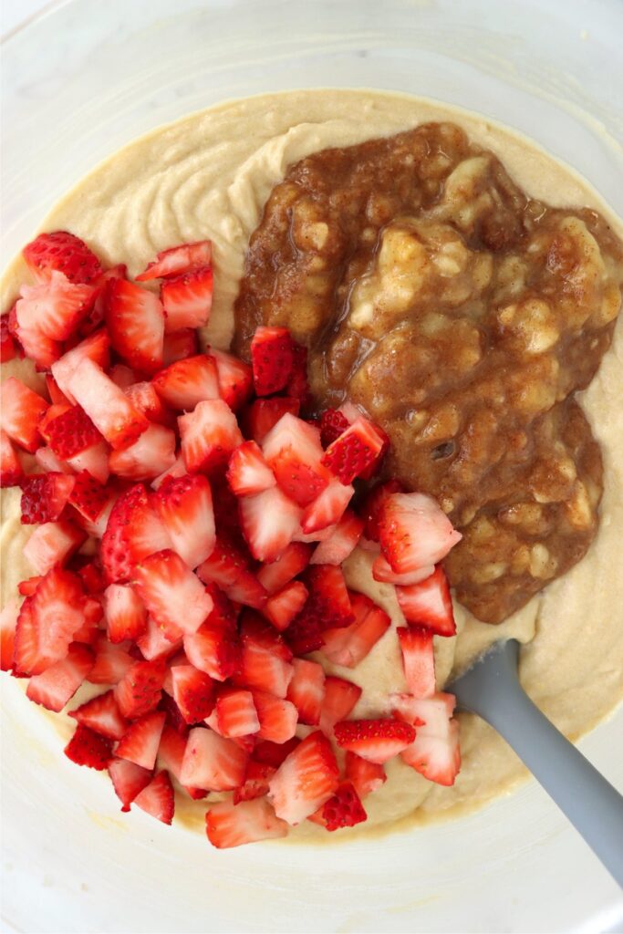 Overhead shot of batter, mashed bananas, and diced strawberries.