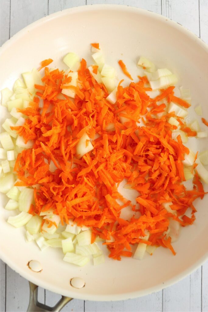 Overhread shot of carrots and onions in skillet