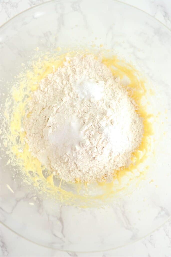 Overhead shot of dry ingredients on top of wet ingredients in mixing bowl