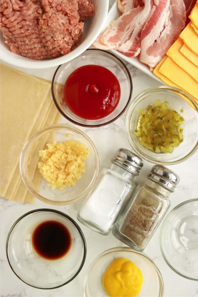Overhead shot of individual bacon cheeseburger egg roll ingredients on table