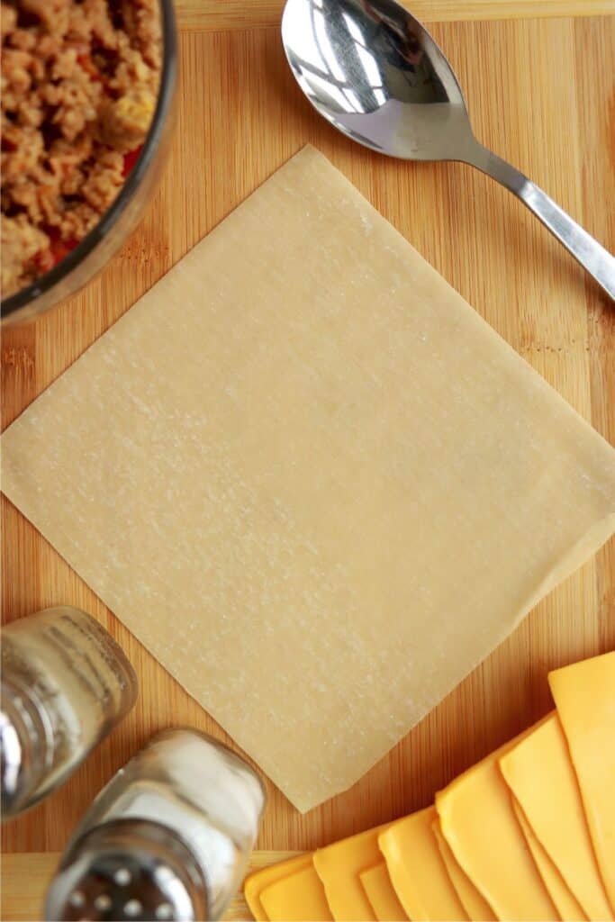 Overhread shot of egg roll wrapper on cutting board