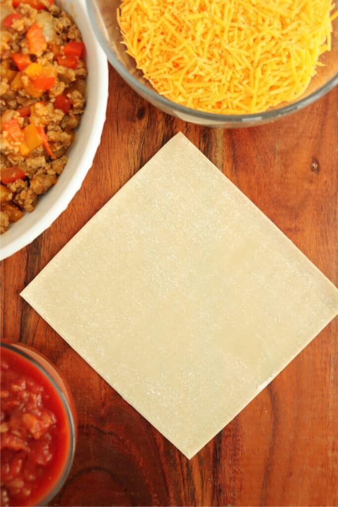 Overhead shot of egg roll wrapper on table. 