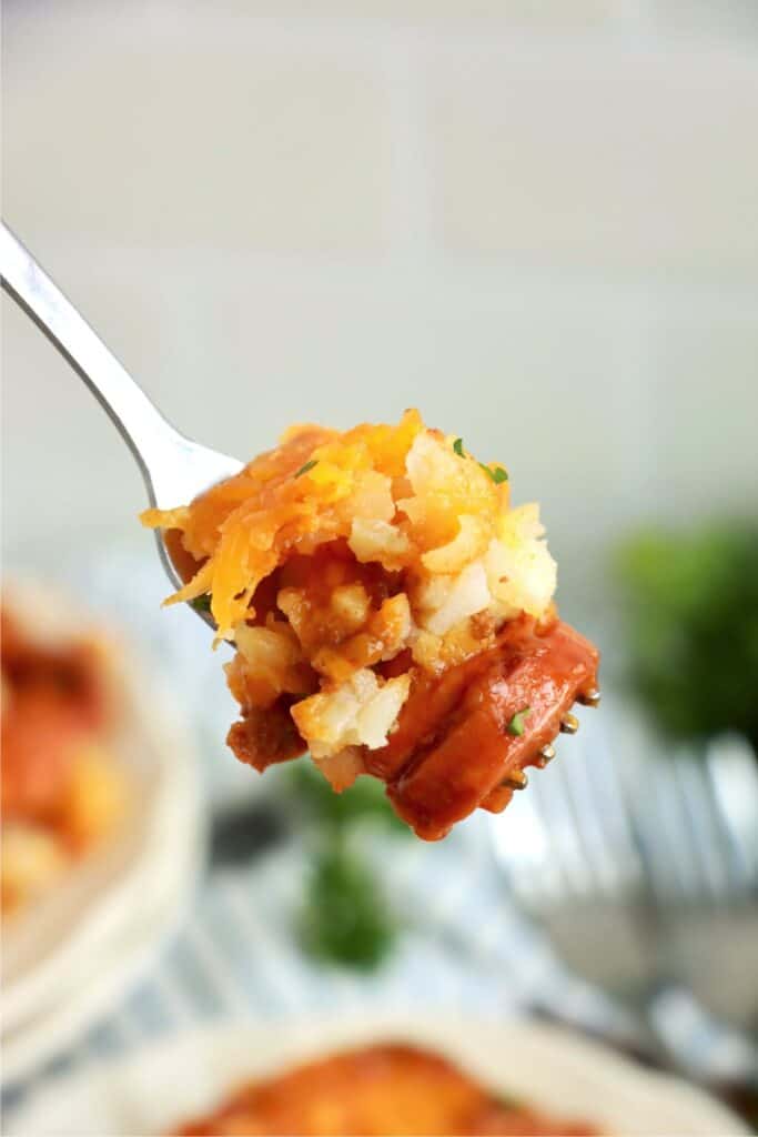 Closeup shot of forkful of chili cheese tater tot hot dog casserole. 